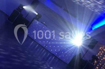 Platines DJ éclairées avec des boutons lumineux colorés et des reflets métalliques dans une ambiance sombre.