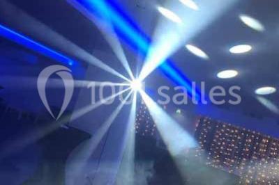 Platines DJ éclairées avec des boutons lumineux colorés et des reflets métalliques dans une ambiance sombre.