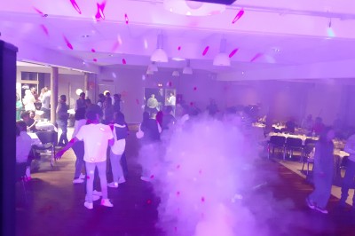 Équipement de sonorisation et éclairage installé dans une salle, comprenant enceintes, projecteurs et table de mixage.