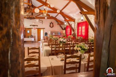 Des personnes dansent en ligne dans une salle décorée de ballons, avec des tables dressées et des convives en arrière-plan.