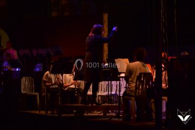 Des personnes dansent dans une ambiance festive avec des lumières colorées dans une salle sombre.