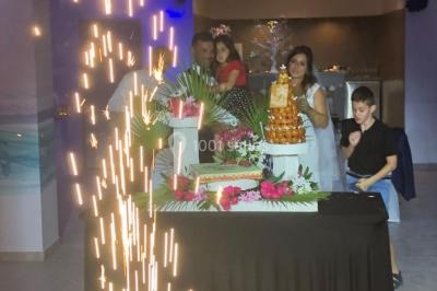 Personnes discutant dans une salle éclairée de lumières bleues, avec tables de buffet et décoration festive.