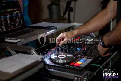Personnes discutant dans une salle éclairée de lumières bleues, avec tables de buffet et décoration festive.