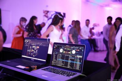 Personnes discutant dans une salle éclairée de lumières bleues, avec tables de buffet et décoration festive.