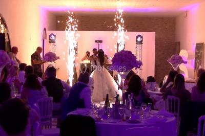 Personnes discutant dans une salle éclairée de lumières bleues, avec tables de buffet et décoration festive.