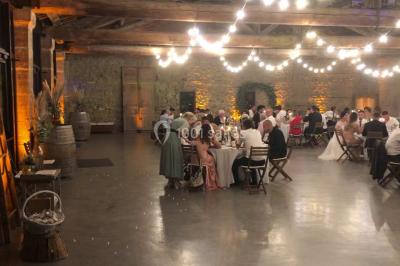 Personnes discutant dans une salle éclairée de lumières bleues, avec tables de buffet et décoration festive.