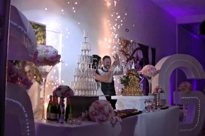 Personnes discutant dans une salle éclairée de lumières bleues, avec tables de buffet et décoration festive.