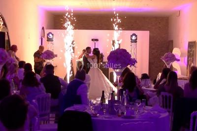 Personnes discutant dans une salle éclairée de lumières bleues, avec tables de buffet et décoration festive.