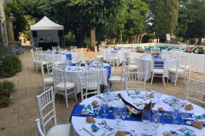 Salle de réception avec des invités assis à des tables, éclairée par des guirlandes lumineuses suspendues.