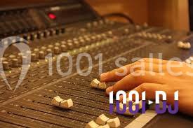 Main ajustant des curseurs sur une table de mixage audio dans un studio.