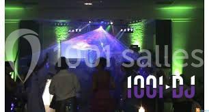 Des personnes dansent dans une salle éclairée par des lumières colorées et des effets laser.