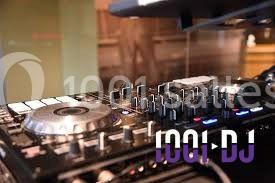 Table de mixage DJ avec boutons, platines et commandes, posée sur une surface dans un environnement intérieur.