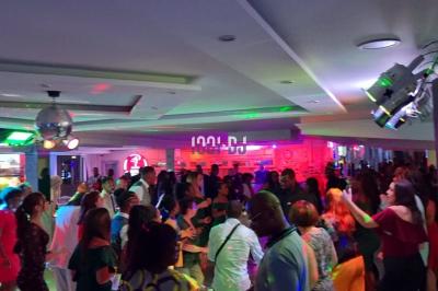 Installation de matériel de sonorisation et éclairage dans une salle avec grandes fenêtres et carrelage au sol.