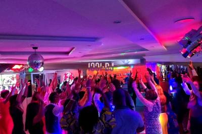 Installation de matériel de sonorisation et éclairage dans une salle avec grandes fenêtres et carrelage au sol.