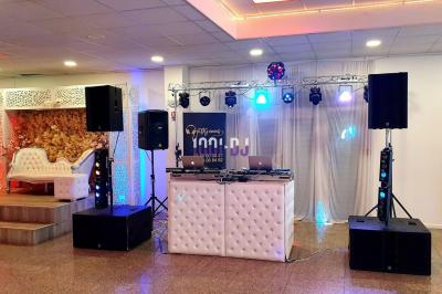 Installation de matériel de sonorisation et éclairage dans une salle avec grandes fenêtres et carrelage au sol.