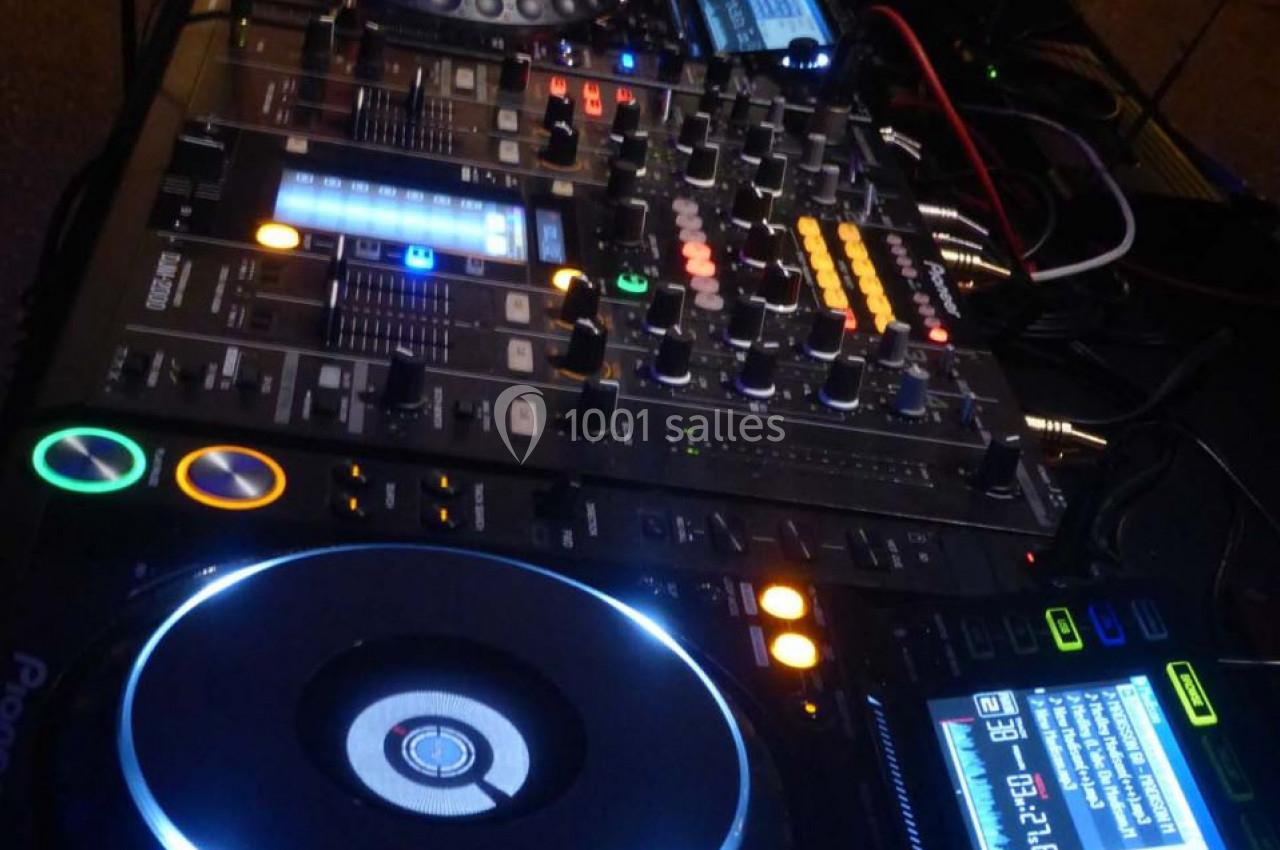 Équipement de DJ comprenant une table de mixage, des platines et un ordinateur portable en arrière-plan.