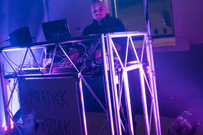 Deux femmes dansent et discutent dans une ambiance festive avec des lumières colorées.