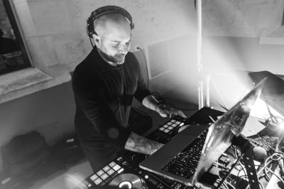 Homme souriant sur un char décoré, entouré de confettis colorés lors d'une parade festive.