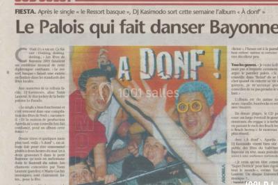 Des personnes souriantes lèvent les bras et posent devant un écran dans une ambiance festive en intérieur.