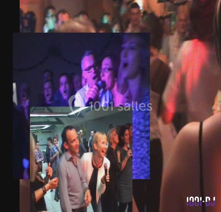 Des personnes chantent et dansent lors d'une fête animée, éclairée par des lumières colorées.