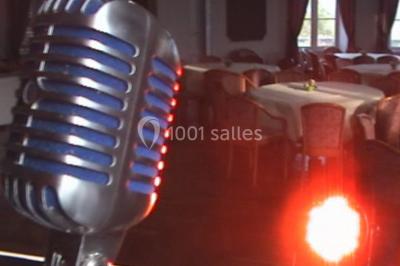 Des personnes souriantes lèvent les bras et posent devant un écran dans une ambiance festive en intérieur.