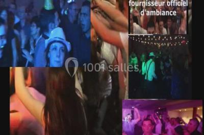 Des personnes souriantes lèvent les bras et posent devant un écran dans une ambiance festive en intérieur.