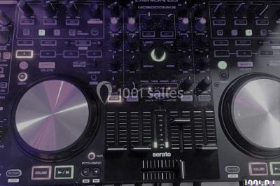 Des personnes souriantes lèvent les bras et posent devant un écran dans une ambiance festive en intérieur.