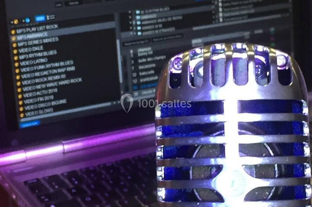 Microphone rétro en gros plan devant un écran d'ordinateur affichant un logiciel de mixage audio.