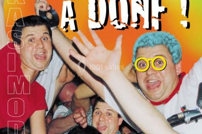 Des personnes souriantes lèvent les bras et posent devant un écran dans une ambiance festive en intérieur.