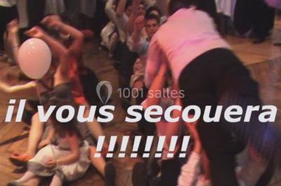 Des personnes souriantes lèvent les bras et posent devant un écran dans une ambiance festive en intérieur.