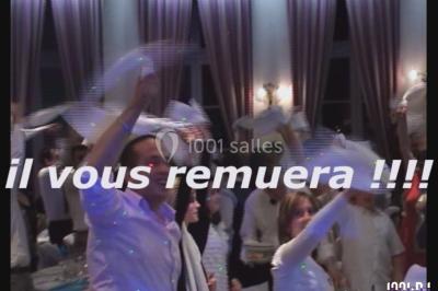 Des personnes souriantes lèvent les bras et posent devant un écran dans une ambiance festive en intérieur.