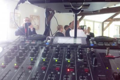 Des personnes souriantes lèvent les bras et posent devant un écran dans une ambiance festive en intérieur.