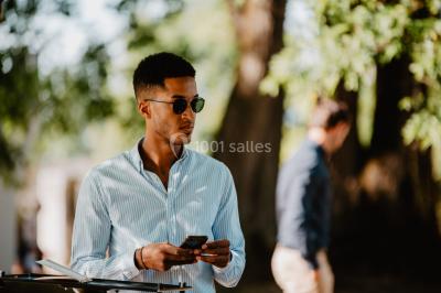 Des personnes dansent et lèvent les bras dans une ambiance festive, éclairée par des lumières colorées.