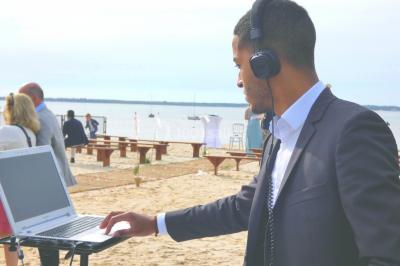 Des invités dansent et célèbrent sous une tente décorée, autour d'une mariée et d'un homme en costume.