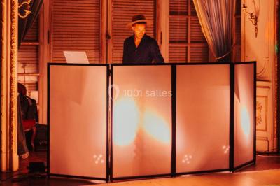 Des invités dansent et célèbrent sous une tente décorée, autour d'une mariée et d'un homme en costume.