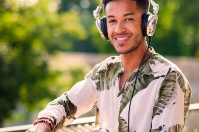 Des invités dansent et célèbrent sous une tente décorée, autour d'une mariée et d'un homme en costume.