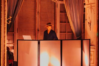 Des invités dansent et célèbrent sous une tente décorée, autour d'une mariée et d'un homme en costume.