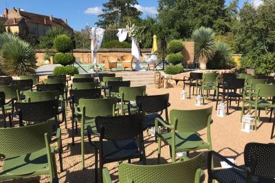 Un DJ portant un casque mixe de la musique sur une table de mixage dans un environnement extérieur couvert.