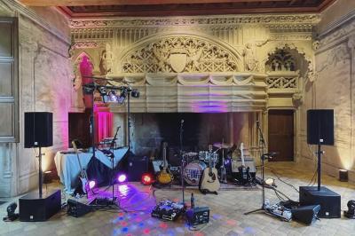 Un DJ portant un casque mixe de la musique sur une table de mixage dans un environnement extérieur couvert.