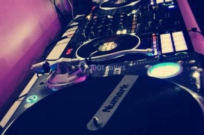 Un homme et une femme sourient devant un fond décoré de feuillage et de rideaux blancs.