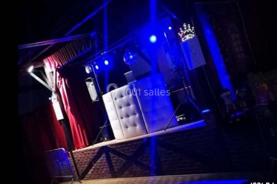 Un homme et une femme sourient devant un fond décoré de feuillage et de rideaux blancs.