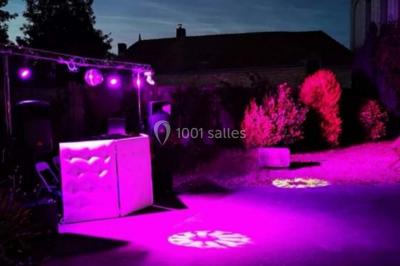 Un homme et une femme sourient devant un fond décoré de feuillage et de rideaux blancs.