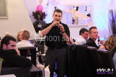 Façade d'un grand bâtiment éclairé par des lumières rouges et oranges dans un environnement nocturne.