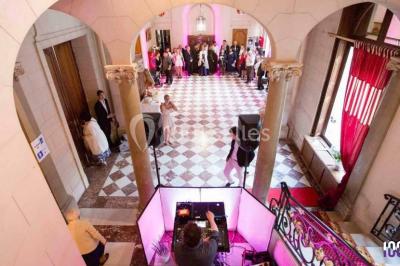Groupe de musiciens jouant sur une scène couverte en plein air, éclairée par des lumières colorées, avec un public devant.