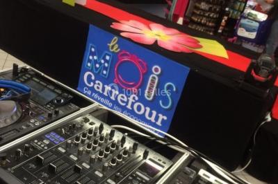 Groupe de musiciens jouant sur une scène couverte en plein air, éclairée par des lumières colorées, avec un public devant.