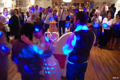 Homme portant des lunettes et un costume bleu, regardant légèrement sur le côté dans un environnement intérieur.