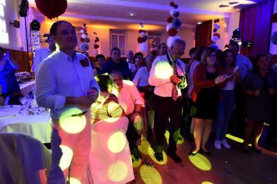 Homme portant des lunettes et un costume bleu, regardant légèrement sur le côté dans un environnement intérieur.