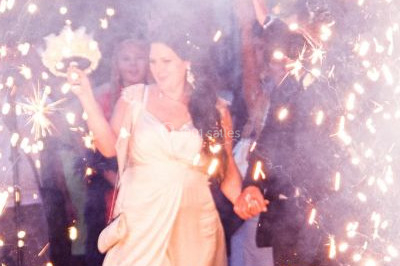 Une femme en robe blanche joue de la harpe dans une salle décorée avec des plantes et des lumières.