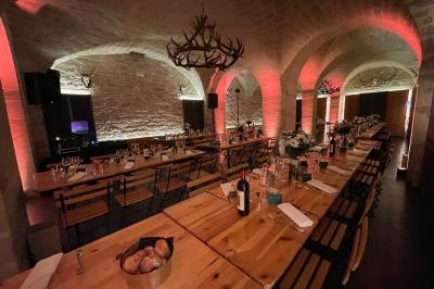 Une femme en robe blanche joue de la harpe dans une salle décorée avec des plantes et des lumières.