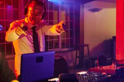 Une femme en robe blanche joue de la harpe dans une salle décorée avec des plantes et des lumières.
